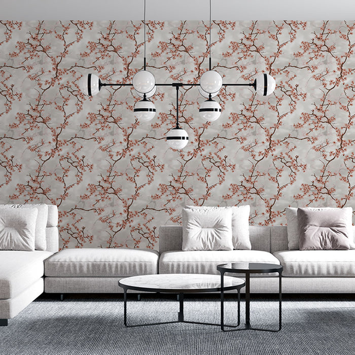 Un salon contemporain avec un papier peint floral aux motifs de branches délicates et fleurs roses sur fond gris, créant une atmosphère douce et apaisante.