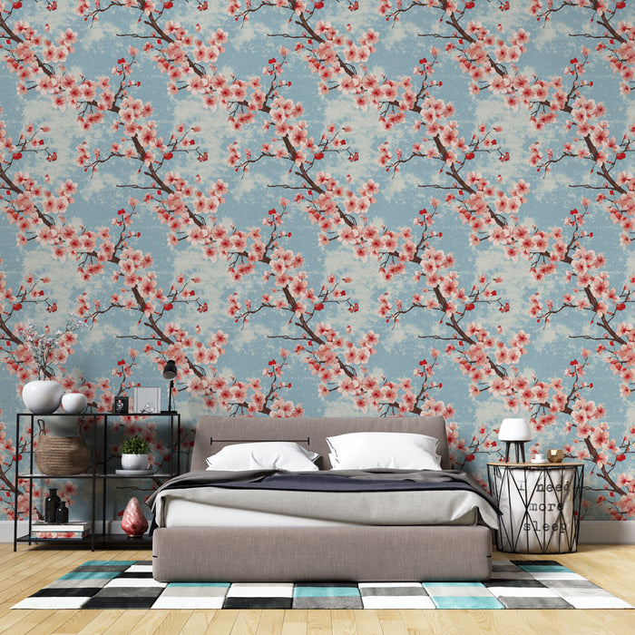 Une chambre moderne avec un papier peint floral aux motifs de branches de cerisier rose sur fond bleu, créant une atmosphère douce et apaisante.