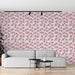 Un salon moderne avec un papier peint floral aux motifs de fleurs roses sur fond blanc, créant une ambiance douce et accueillante.