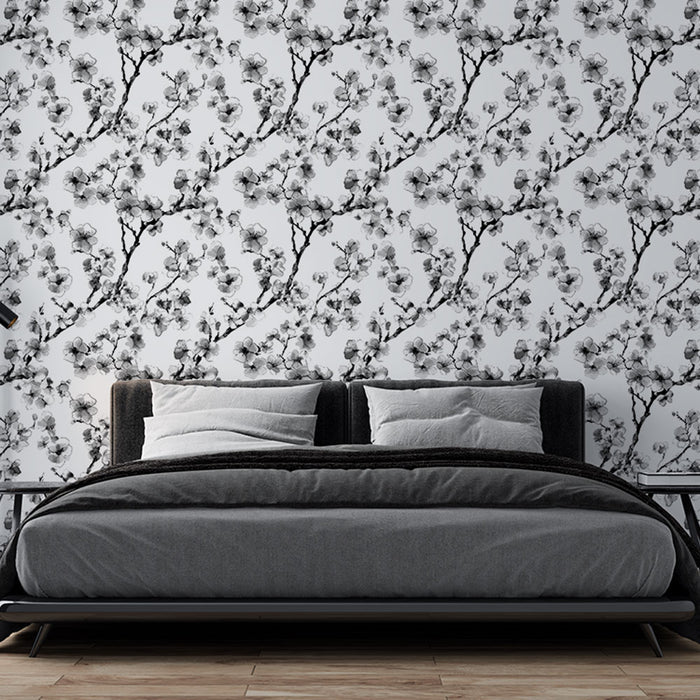 Une chambre moderne avec un papier peint floral noir et blanc représentant des branches délicates de fleurs, créant une atmosphère élégante et apaisante.