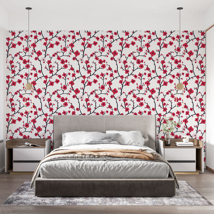Une chambre moderne avec un papier peint floral aux motifs de branches noires ornées de fleurs rouges et roses sur fond blanc, créant une ambiance fraîche et vivifiante.