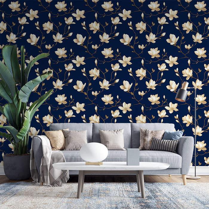 Un salon moderne avec un papier peint floral bleu nuit orné de grandes fleurs blanches et de branches dorées, créant une atmosphère élégante et apaisante.