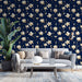 Un salon moderne avec un papier peint floral bleu nuit orné de grandes fleurs blanches et de branches dorées, créant une atmosphère élégante et apaisante.