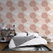Une chambre moderne avec un papier peint floral aux roses roses et blanches sur fond beige, créant une atmosphère douce et romantique.