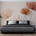 Une chambre moderne avec un papier peint floral aux grandes fleurs délicates dans des teintes chaudes de rose et d'orange sur fond beige, créant une atmosphère douce et accueillante.