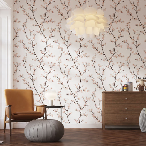 Une pièce lumineuse avec un papier peint floral aux branches délicates et fleurs roses sur fond clair, créant une ambiance douce et apaisante.