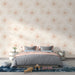 Une chambre apaisante avec un papier peint floral aux motifs délicats de fleurs roses sur fond crème, créant une atmosphère douce et chaleureuse.
