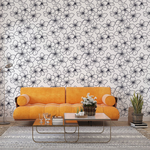 Un salon moderne avec un papier peint floral noir et blanc représentant des fleurs délicates, créant une atmosphère élégante et apaisante.