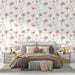 Une chambre élégante avec un papier peint floral aux motifs de coquelicots rouges sur fond crème, créant une atmosphère douce et romantique.