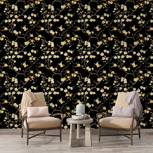 Un salon élégant avec un papier peint floral noir orné de branches dorées et de fleurs blanches, créant une atmosphère chic et apaisante.