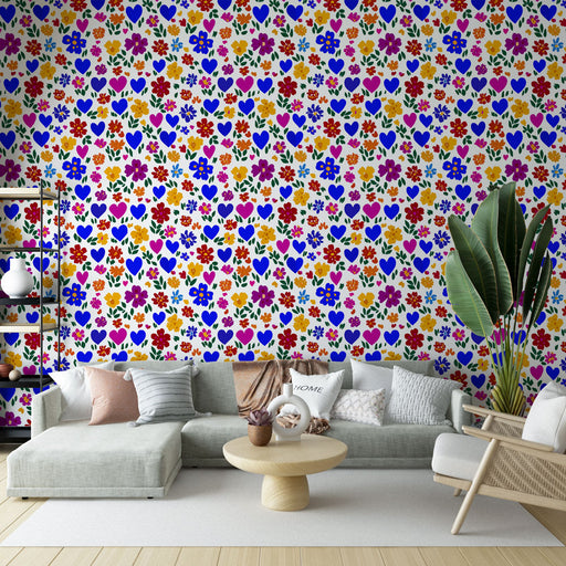 Un salon lumineux avec un papier peint coloré aux motifs de fleurs et cœurs sur fond clair, créant une ambiance joyeuse et accueillante.