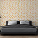 Une chambre moderne avec un papier peint aux motifs ensoleillés dans des teintes de rose et jaune sur fond clair, créant une atmosphère chaleureuse et joyeuse.