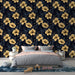 Une chambre moderne avec un papier peint floral aux grandes fleurs dorées sur fond noir, créant une ambiance tropicale et élégante.