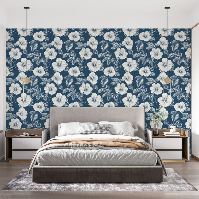 Une chambre moderne avec un papier peint floral bleu marine et blanc, illustrant de grandes fleurs exotiques qui créent une ambiance tropicale et apaisante.