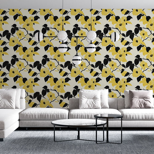 Un salon moderne avec un papier peint floral aux motifs jaunes et noirs sur fond clair, apportant une ambiance fraîche et vivante.
