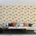 Un salon moderne avec un papier peint floral beige orné de grandes fleurs jaunes et de feuilles noires, créant une atmosphère chaleureuse et accueillante.