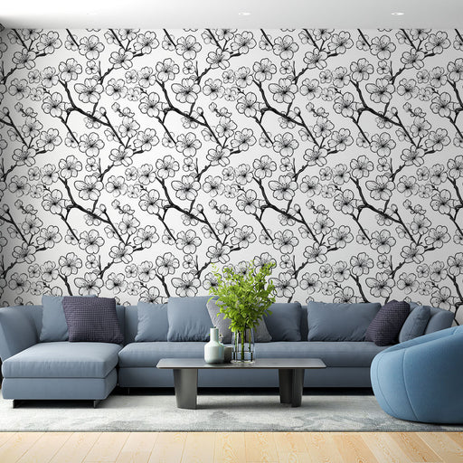 Un salon moderne avec un papier peint floral noir et blanc représentant des branches de cerisier, créant une atmosphère élégante et apaisante.