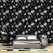Une chambre moderne avec un papier peint floral noir et blanc, où des fleurs stylisées et des feuilles créent une ambiance élégante et contemporaine.