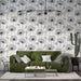 Un salon moderne avec un papier peint floral en noir et blanc, agrémenté de touches jaunes, créant une atmosphère à la fois fraîche et artistique.