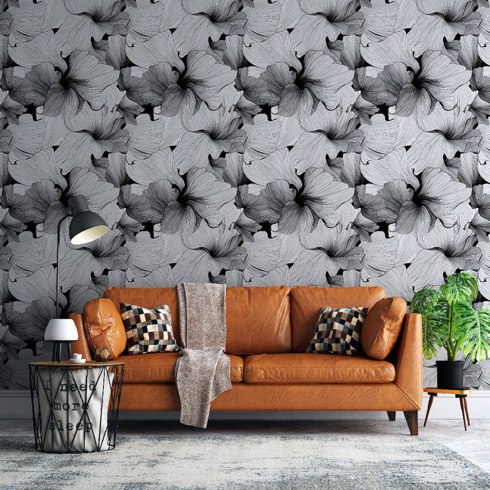 Un salon moderne avec un papier peint floral noir et blanc représentant de grandes fleurs stylisées, créant une atmosphère élégante et artistique.