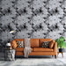 Un salon moderne avec un papier peint floral noir et blanc représentant de grandes fleurs stylisées, créant une atmosphère élégante et artistique.
