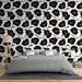Une chambre élégante avec un papier peint floral noir et or sur fond blanc, créant une ambiance moderne et sophistiquée.