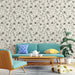 Un salon moderne avec un papier peint floral beige et noir, orné de délicates fleurs et feuillages, créant une atmosphère douce et élégante.