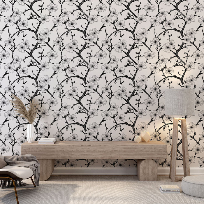Une pièce lumineuse avec un papier peint floral noir et blanc représentant des branches délicates ornées de fleurs, créant une atmosphère élégante et apaisante.