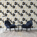 Un salon contemporain avec un papier peint floral noir et blanc, orné de fleurs aux touches dorées, créant une ambiance élégante et raffinée.
