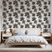 Une chambre moderne avec un papier peint floral noir et or sur fond blanc, créant une ambiance élégante et artistique.