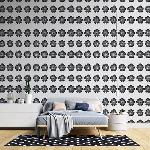Une chambre moderne avec un papier peint floral noir sur fond blanc, créant une ambiance élégante et graphique.