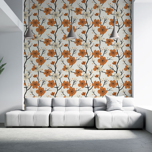 Un salon moderne avec un papier peint floral aux motifs orange et noir sur fond clair, créant une ambiance chaleureuse et accueillante.