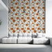 Un salon moderne avec un papier peint floral aux motifs orange et noir sur fond clair, créant une ambiance chaleureuse et accueillante.