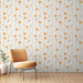 Une pièce lumineuse avec un papier peint floral aux motifs de fleurs orange et beige sur fond clair, créant une ambiance joyeuse et accueillante.