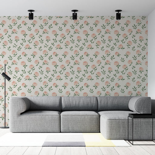 Un salon moderne avec un papier peint floral aux motifs de fleurs roses et feuillage vert sur fond clair, créant une atmosphère douce et accueillante.