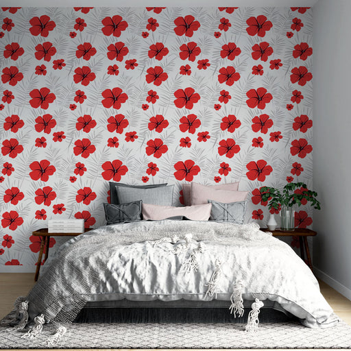 Une chambre lumineuse avec un papier peint floral aux grandes fleurs rouges sur fond blanc, créant une ambiance tropicale et vivifiante.