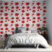 Une chambre lumineuse avec un papier peint floral aux grandes fleurs rouges sur fond blanc, créant une ambiance tropicale et vivifiante.