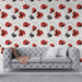 Un salon contemporain avec un papier peint floral aux motifs de coquelicots rouges et noirs sur fond blanc, créant une ambiance vivante et artistique.