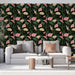 Un salon moderne avec un papier peint tropical aux motifs de feuilles vertes et fleurs roses sur fond noir, créant une ambiance vivante et chaleureuse.