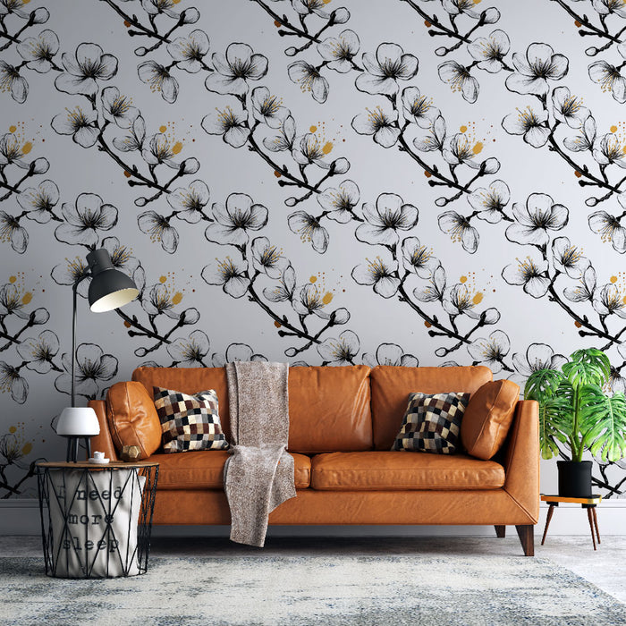 Un salon moderne avec un papier peint floral noir et blanc illustrant des branches de fleurs délicates sur un fond gris, créant une atmosphère douce et élégante.