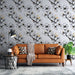 Un salon moderne avec un papier peint floral noir et blanc illustrant des branches de fleurs délicates sur un fond gris, créant une atmosphère douce et élégante.