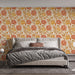 Une chambre moderne avec un papier peint floral aux teintes chaudes d'orange et de jaune, créant une atmosphère accueillante et dynamique.