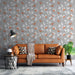 Un salon moderne avec un papier peint floral gris orné de motifs de fleurs blanches et orange, créant une atmosphère chaleureuse et accueillante.