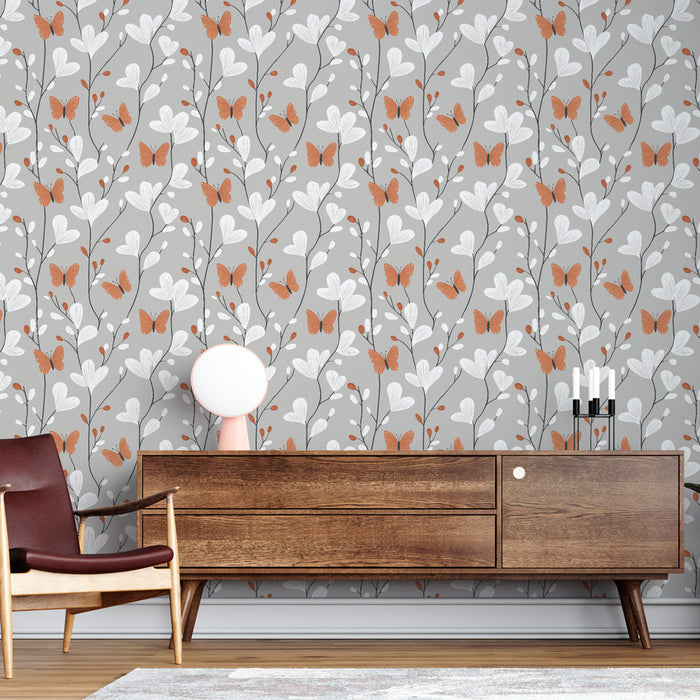 Une pièce moderne avec un papier peint floral sur fond gris, orné de motifs de papillons orange et de feuilles blanches, créant une ambiance douce et accueillante.