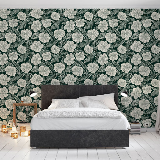 Une chambre moderne avec un papier peint floral vert foncé et crème, évoquant une ambiance tropicale et apaisante.