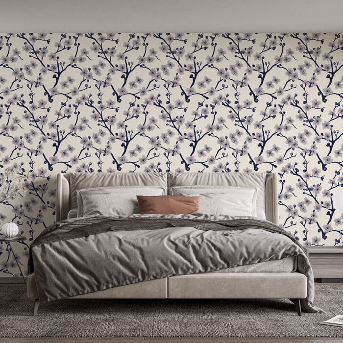 Une chambre élégante avec un papier peint floral bleu marine sur fond crème, évoquant une ambiance douce et apaisante grâce à ses motifs délicats de branches fleuries.