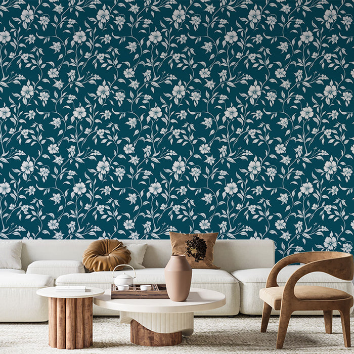 Un salon moderne avec un papier peint floral bleu canard et blanc aux motifs délicats, créant une atmosphère élégante et apaisante.