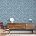 Une pièce moderne avec un papier peint floral bleu orné de petites fleurs colorées créant une ambiance fraîche et accueillante.