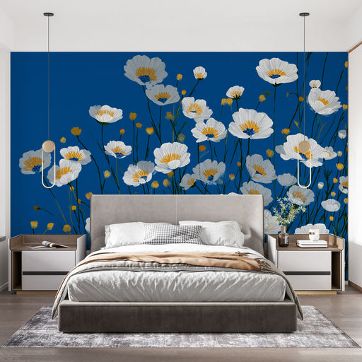 Une chambre moderne avec un papier peint floral sur fond bleu, mettant en valeur de grandes fleurs blanches et des touches dorées, créant une atmosphère fraîche et dynamique.
