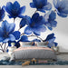 Une chambre moderne avec un papier peint floral bleu vibrant représentant de grandes fleurs délicates sur fond blanc, créant une atmosphère apaisante et élégante.